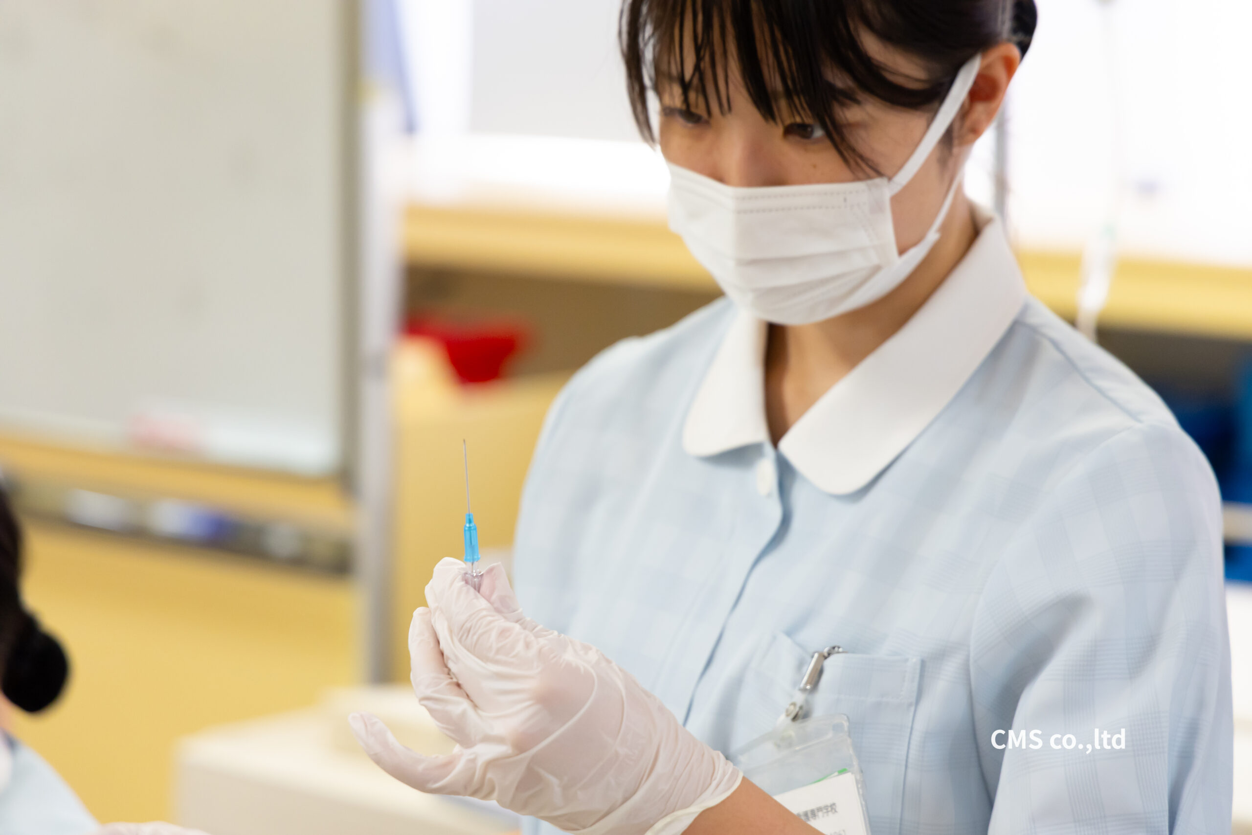 注射器の薬液や気泡を確認する看護学生のアップ写真（専門学校施設紹介動画撮影素材）