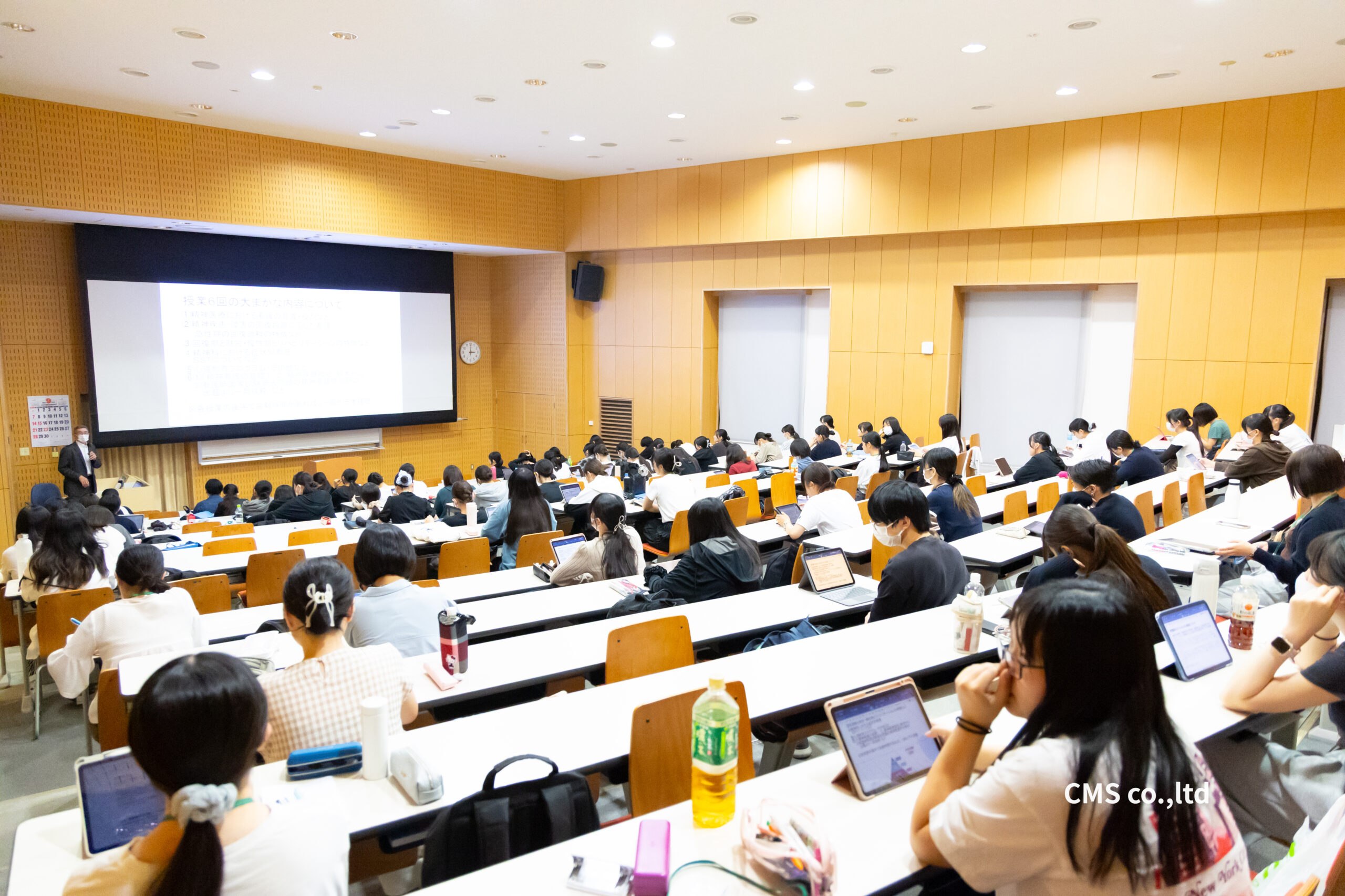 熱心に講義を聴講しノートやタブレットで学ぶ看護専門学校の学生たち