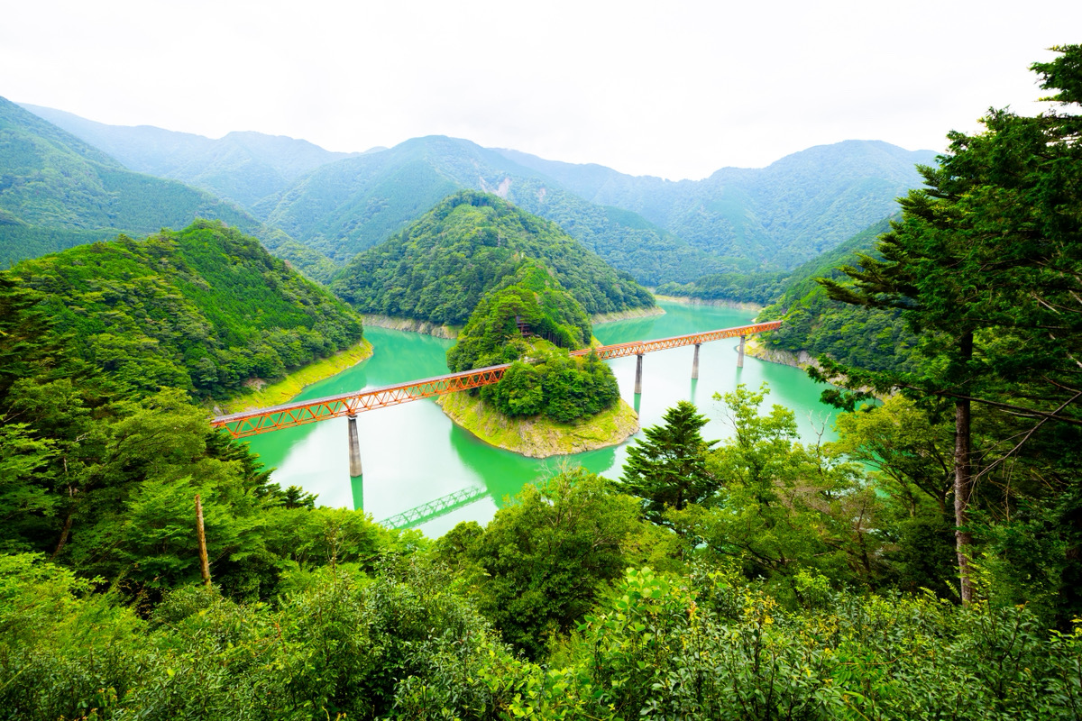 大井川鐡道井川線「奥大井湖上駅」の全景。エメラルドグリーンの湖面と赤い鉄橋を鮮明に捉えた風景画像撮影