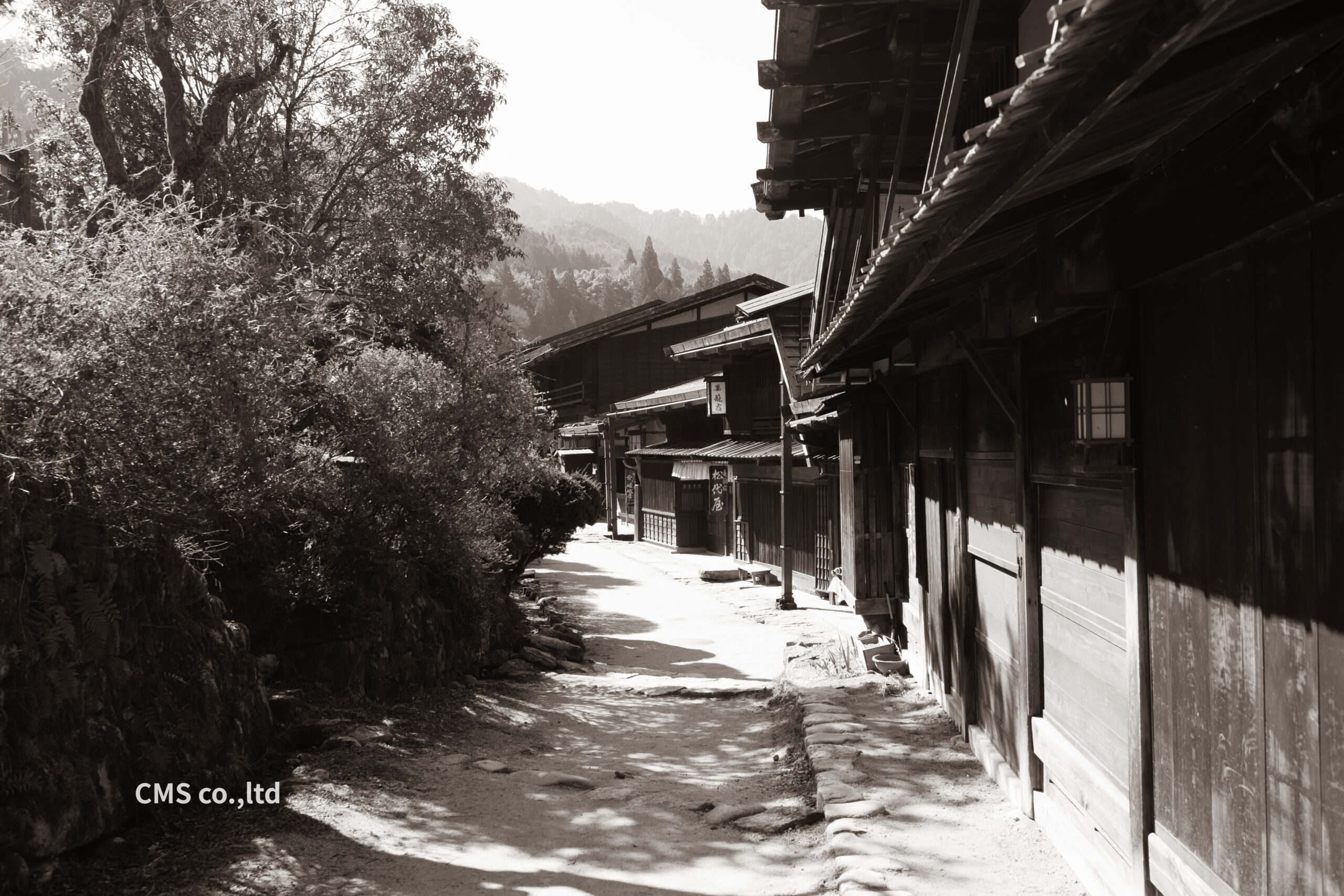 未舗装の土の小路が伝統的な木造家屋に挟まれて続く妻籠宿の景色